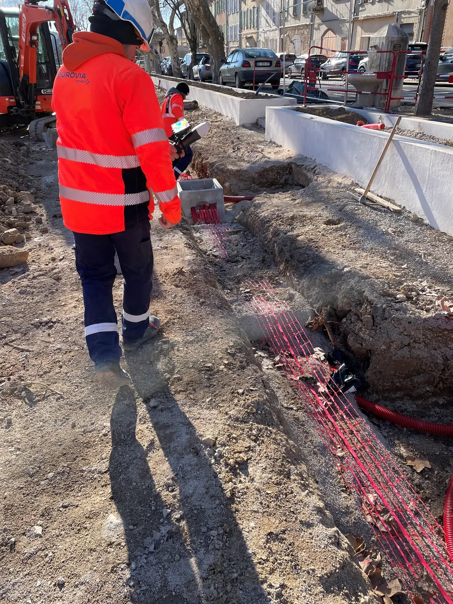 Équipe de travaux publics sur chantier avec tranchée ouverte